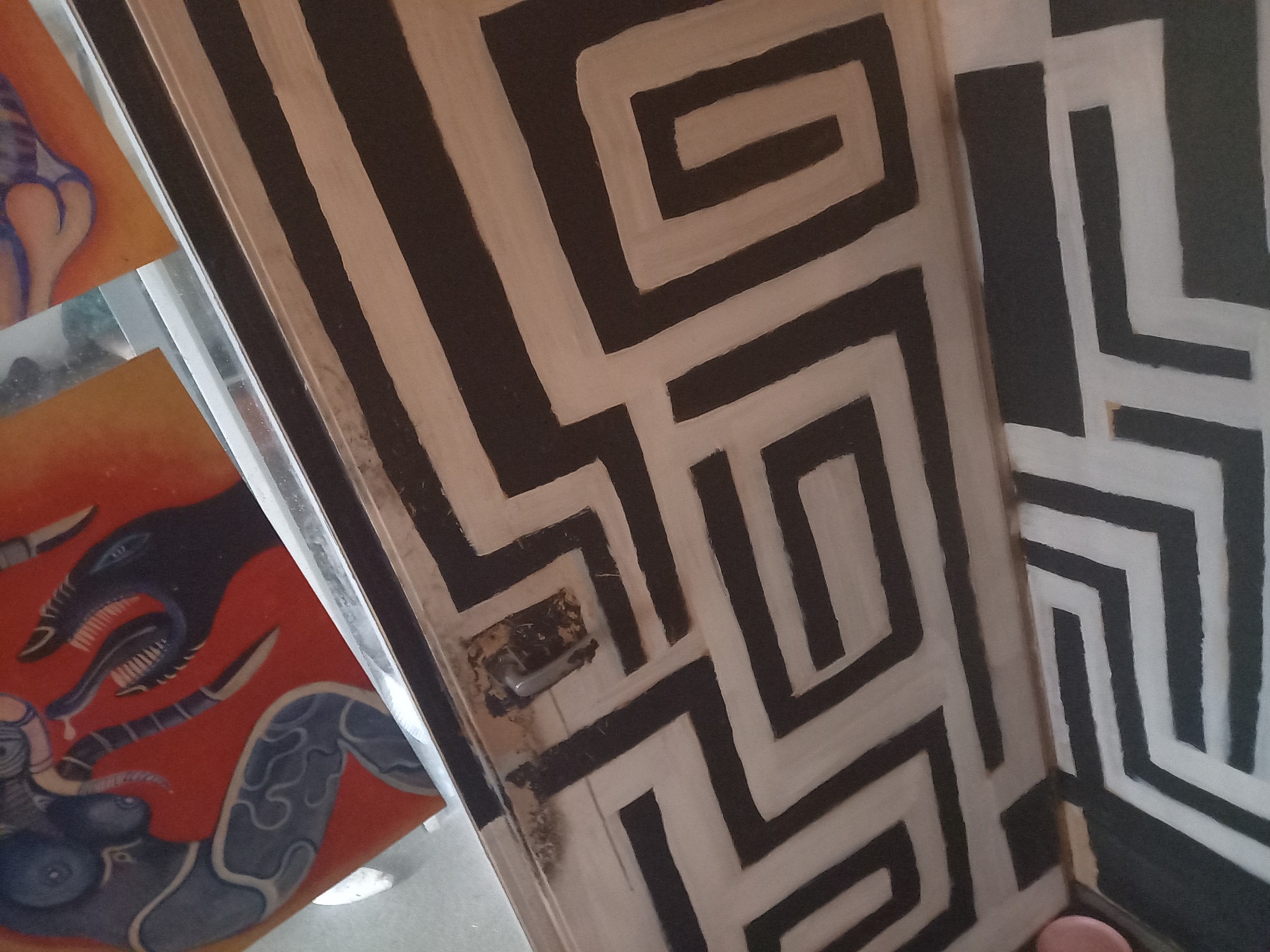 Zwarte deur met witte labyrint patronen detail